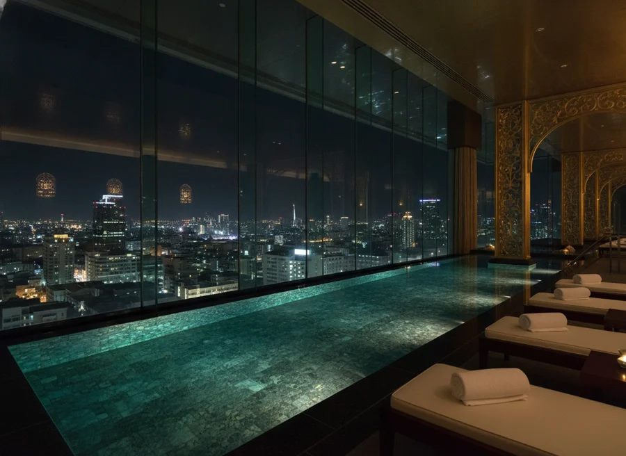 Indoor infinity pool with glass-walled city skyline views